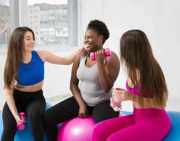 Rehasport Frauen trainieren mit Fitnessball und Gewichten